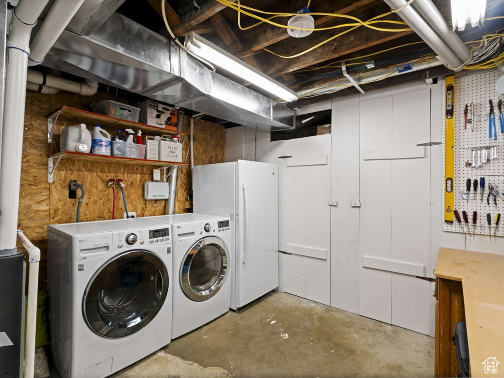 Clothes washing area featuring laundry area, washer and dryer, and a workshop area