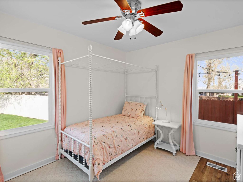 Bedroom with visible vents, a ceiling fan, baseboards, and wood finished floors