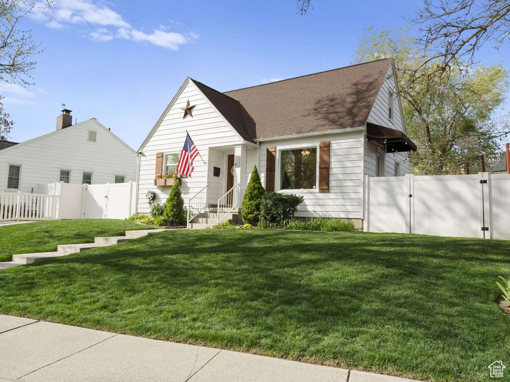 View of front of property featuring fence, a gate, and a front yard
