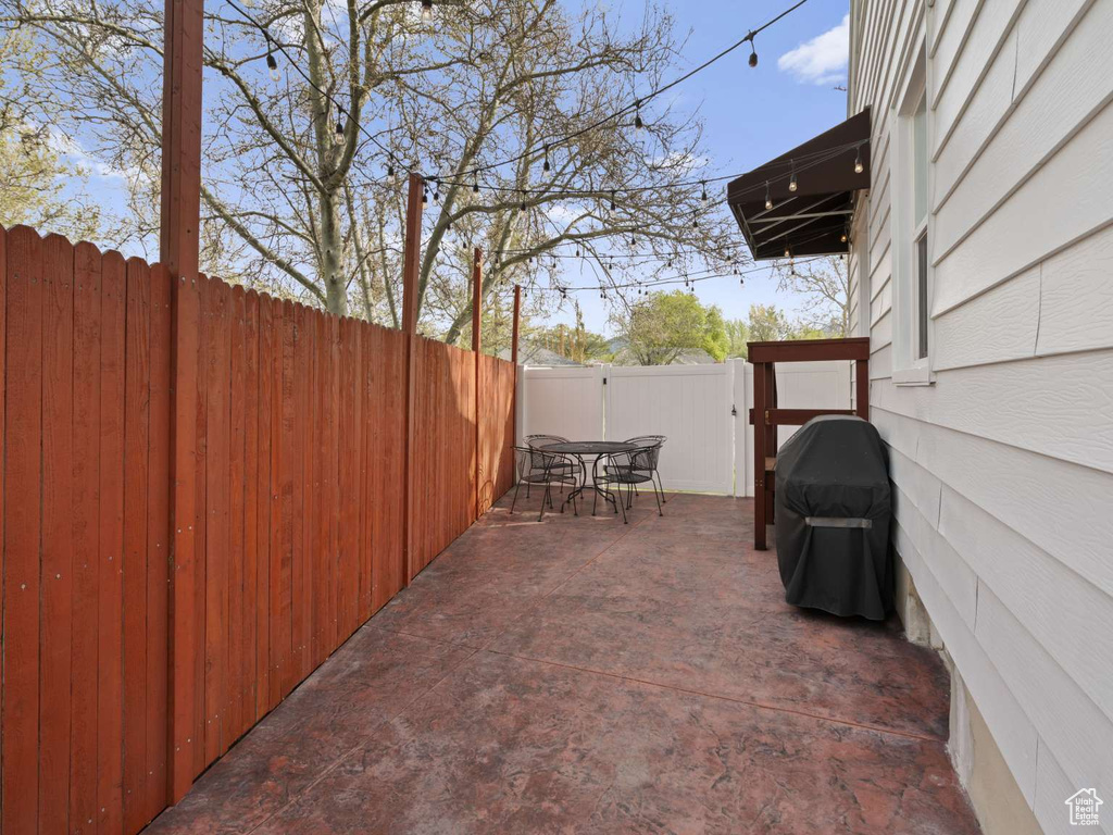 View of patio featuring fence, grilling area, and outdoor dining space