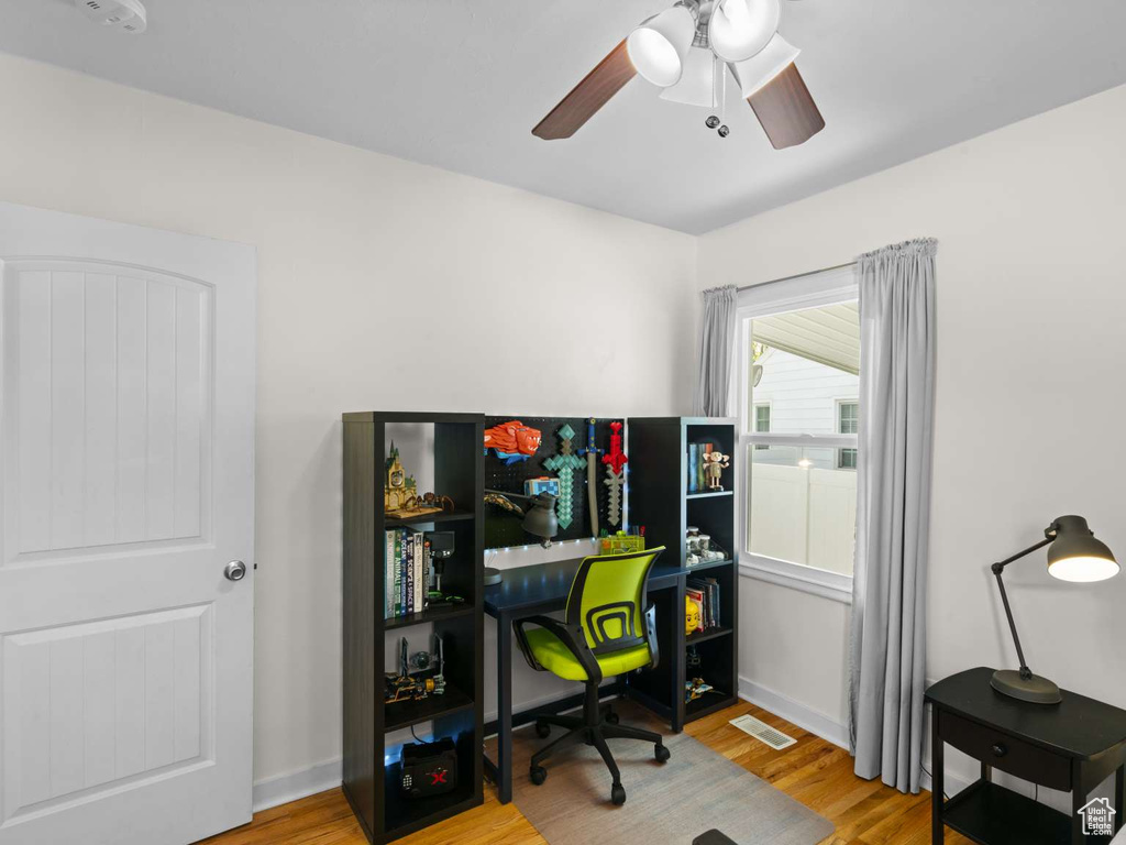 Home office featuring a ceiling fan, visible vents, and light wood finished floors