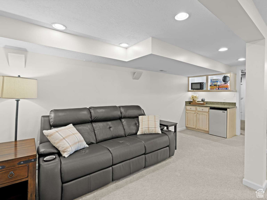 Living room with baseboards, recessed lighting, and light carpet