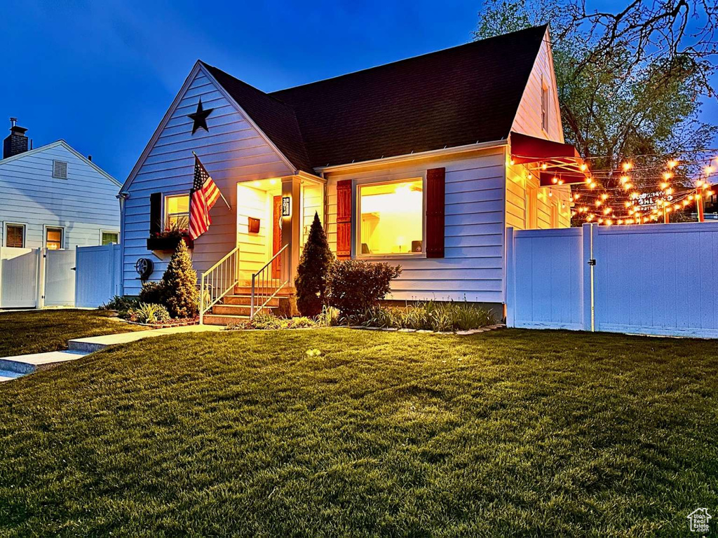 View of front facade with fence, a gate, and a front yard