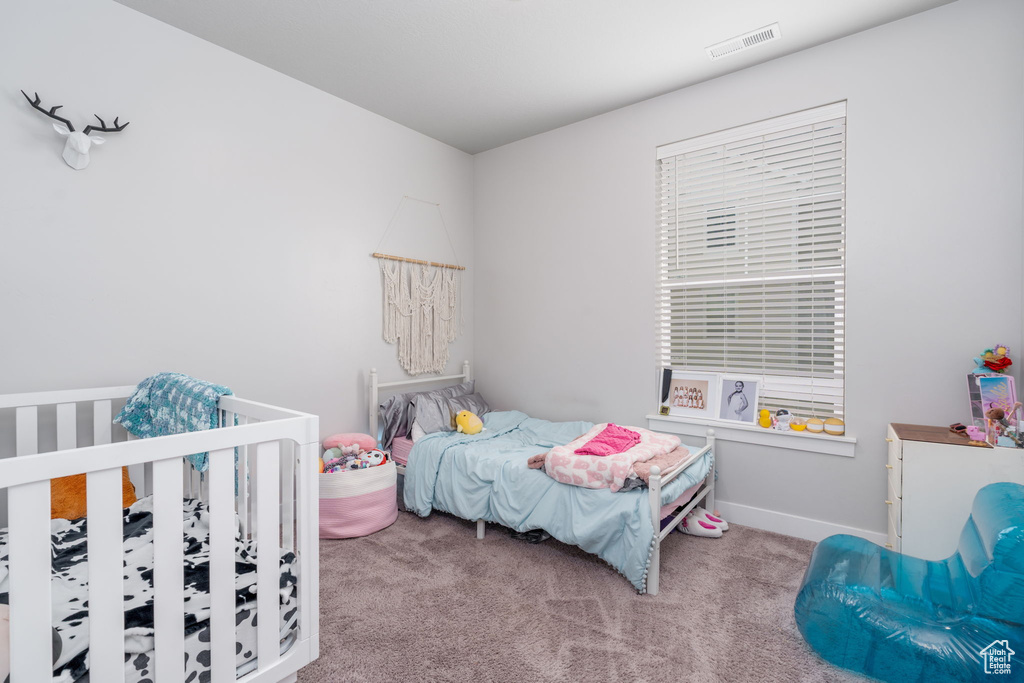 Carpeted bedroom with visible vents and baseboards