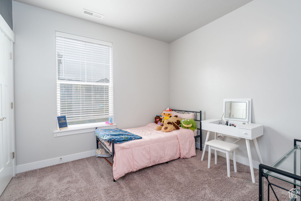 Carpeted bedroom featuring baseboards and visible vents