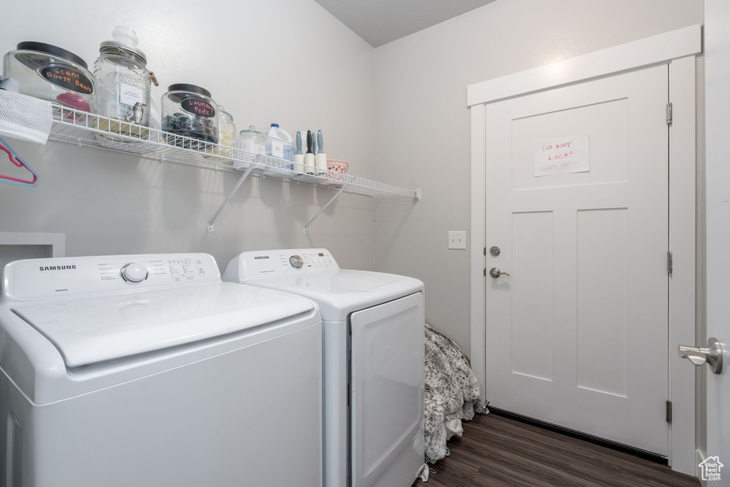 Laundry area with laundry area, dark wood-style floors, and washer and clothes dryer