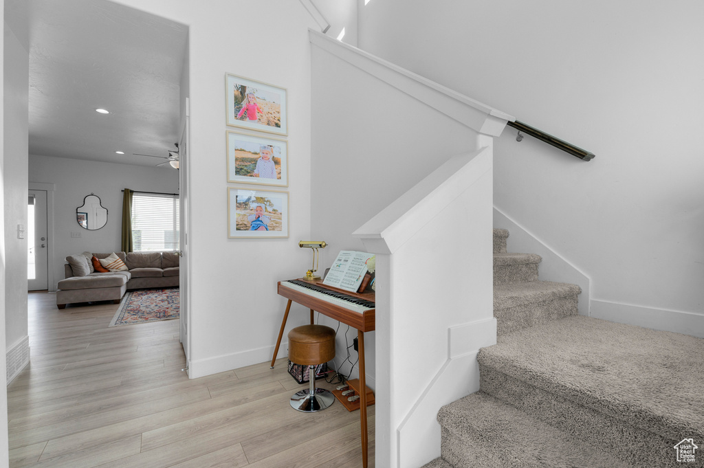 Stairway featuring baseboards, recessed lighting, ceiling fan, and wood finished floors