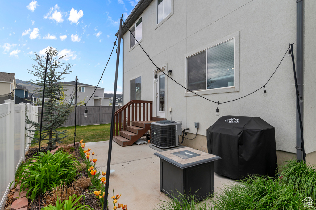 View of patio featuring fence, central AC unit, and area for grilling