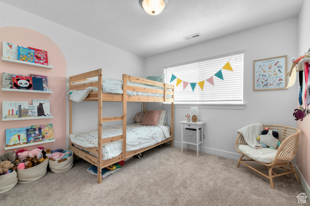 Carpeted bedroom featuring baseboards and visible vents