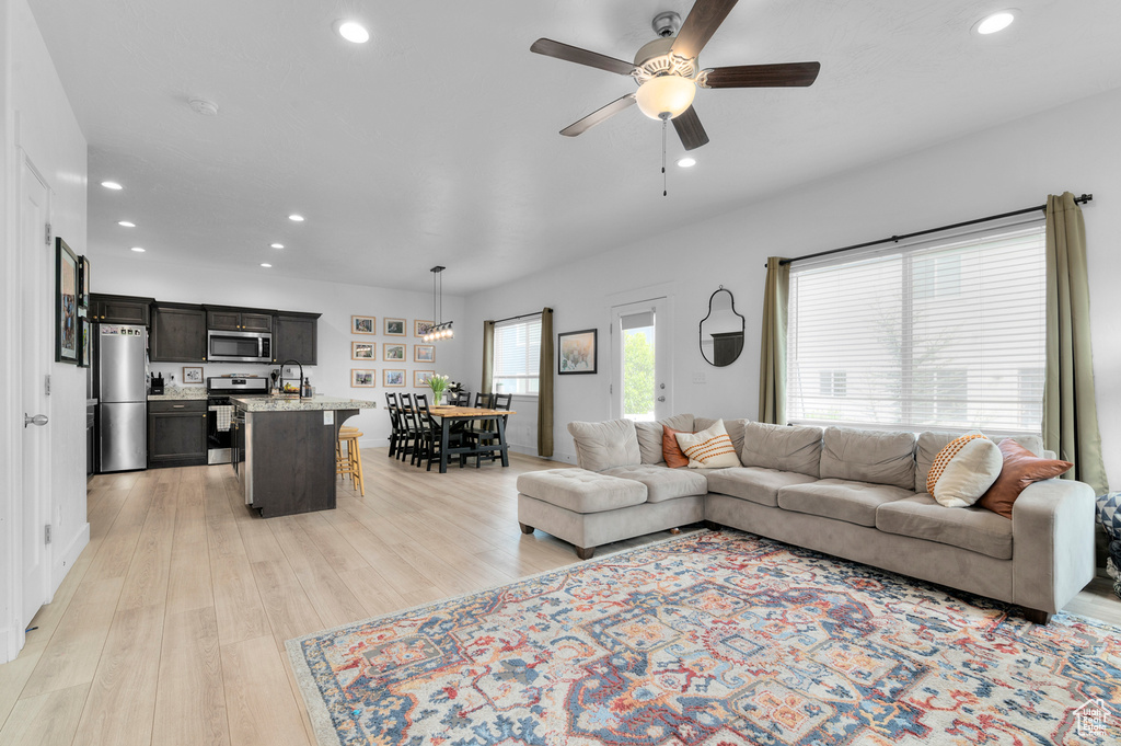 Living area with recessed lighting, ceiling fan, and light wood finished floors