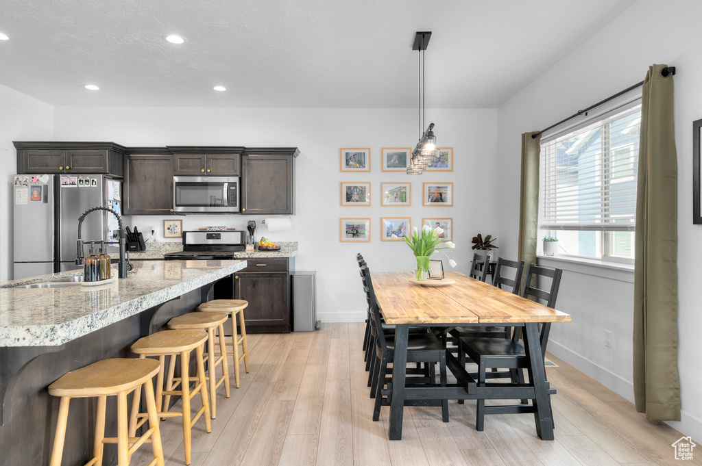 Kitchen with light wood-style floors, recessed lighting, baseboards, and appliances with stainless steel finishes