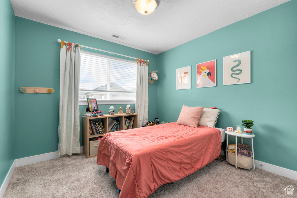 Bedroom featuring carpet floors, baseboards, and visible vents