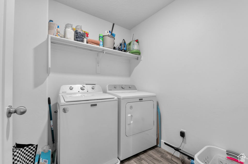 Laundry room featuring laundry area, light wood finished floors, and washing machine and clothes dryer