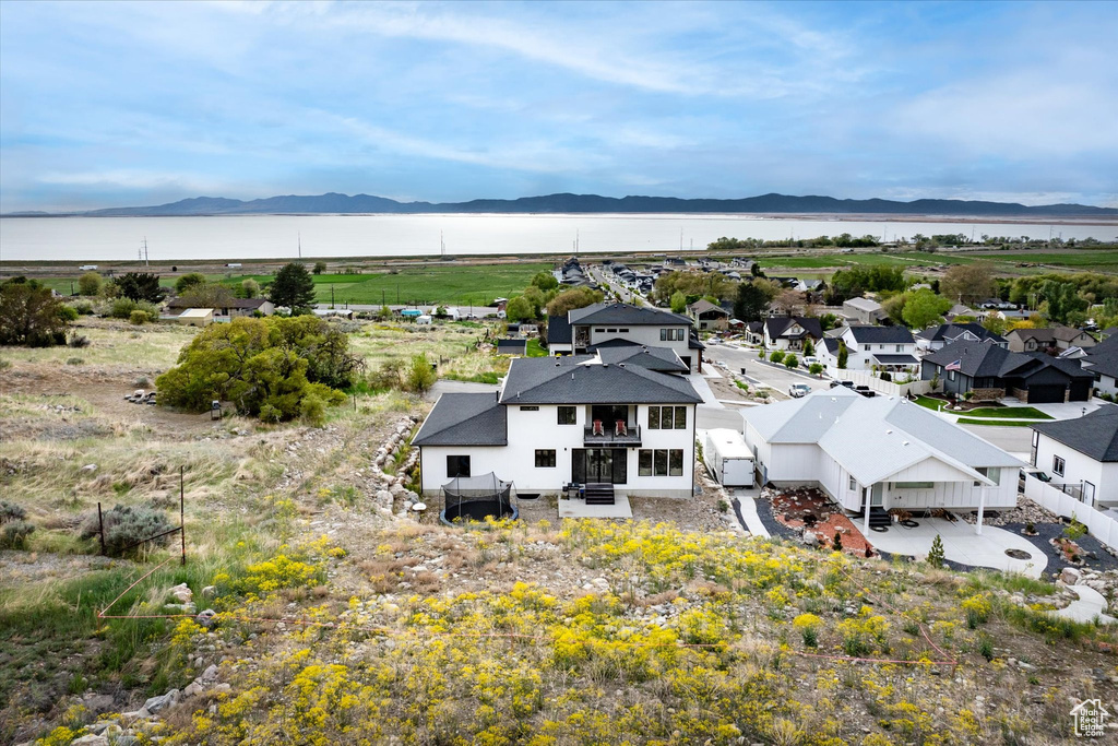 Birds eye view of property featuring a water and mountain view and a residential view