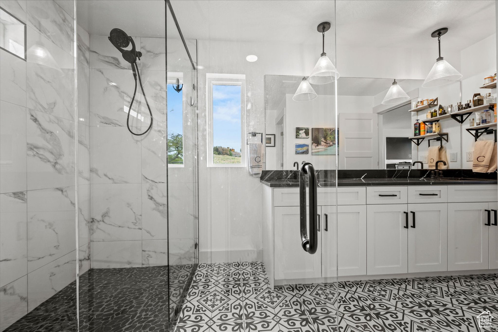 Full bathroom with vanity and a marble finish shower