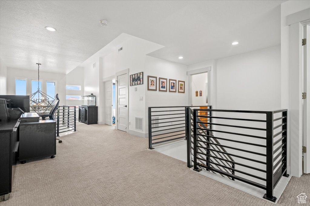 Corridor featuring carpet floors, recessed lighting, visible vents, and an upstairs landing