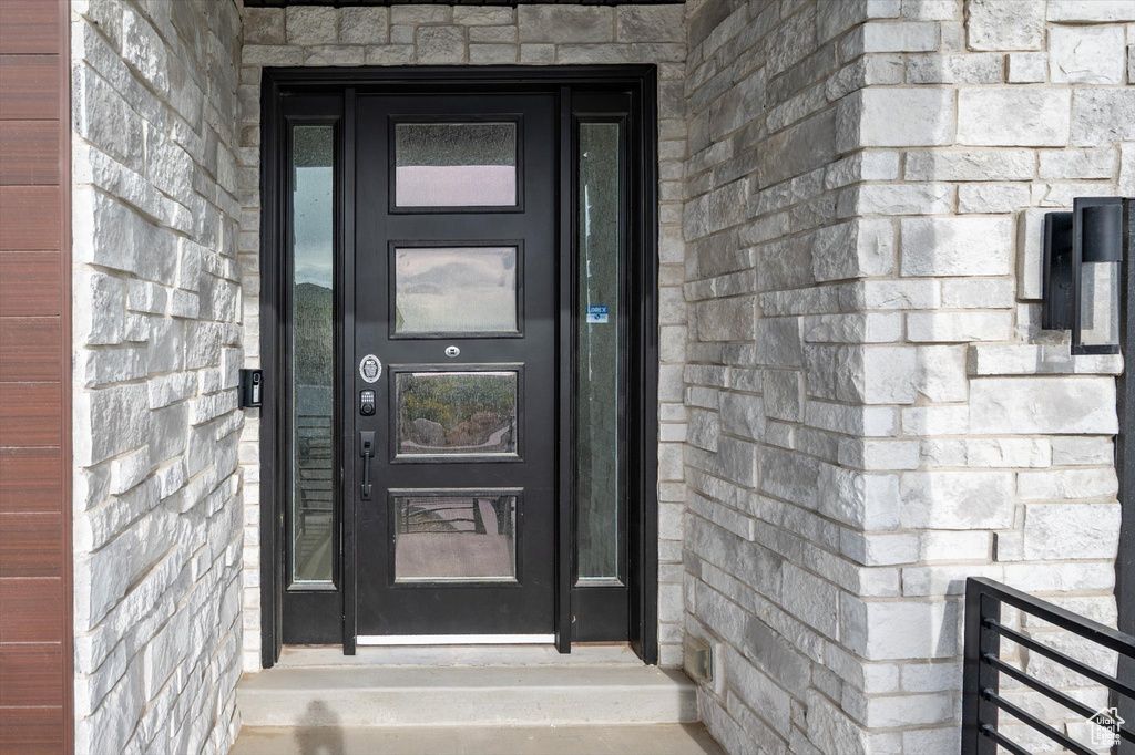 Doorway to property featuring stone siding