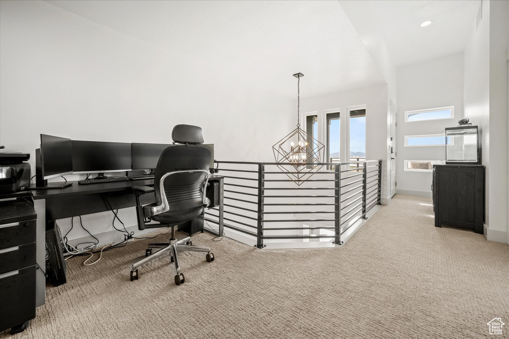 Carpeted office space with an inviting chandelier and baseboards
