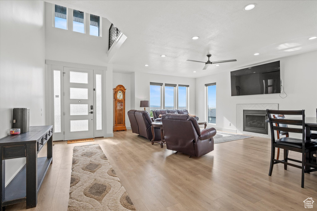Living room featuring a glass covered fireplace, ceiling fan, recessed lighting, and wood finished floors