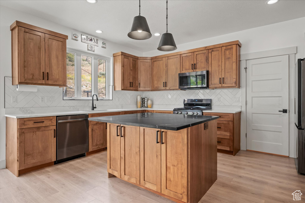 Kitchen with recessed lighting, light wood-style floors, and appliances with stainless steel finishes