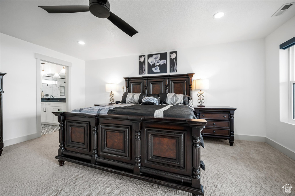 Bedroom featuring connected bathroom, baseboards, visible vents, and light carpet