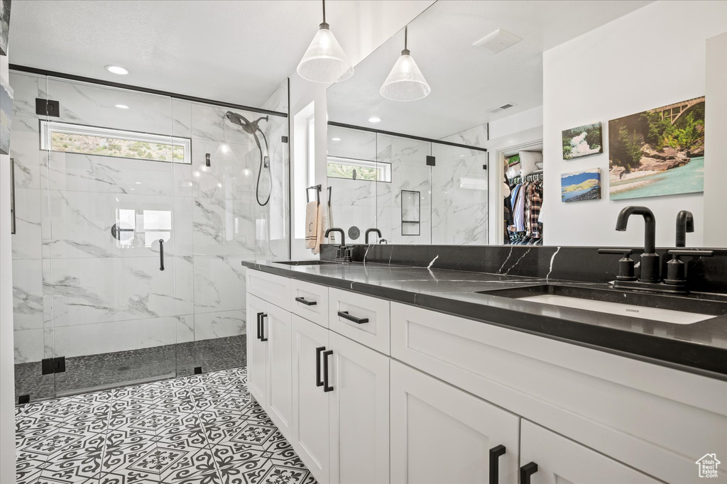 Full bath with a sink, a marble finish shower, and a healthy amount of sunlight