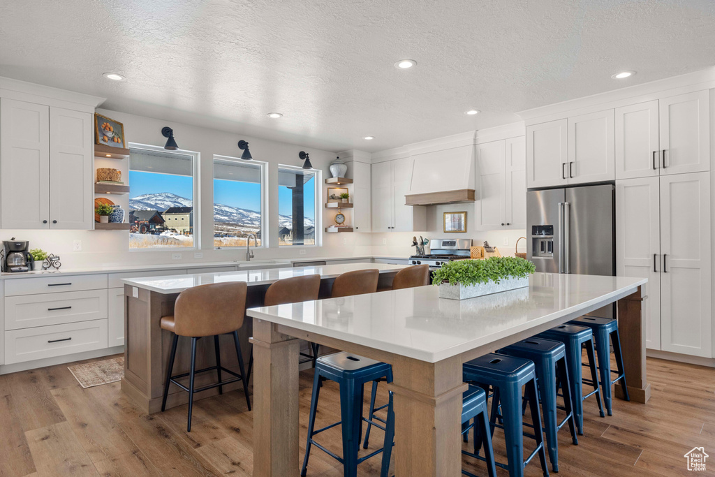 Kitchen featuring a center island, open shelves, and appliances with stainless steel finishes