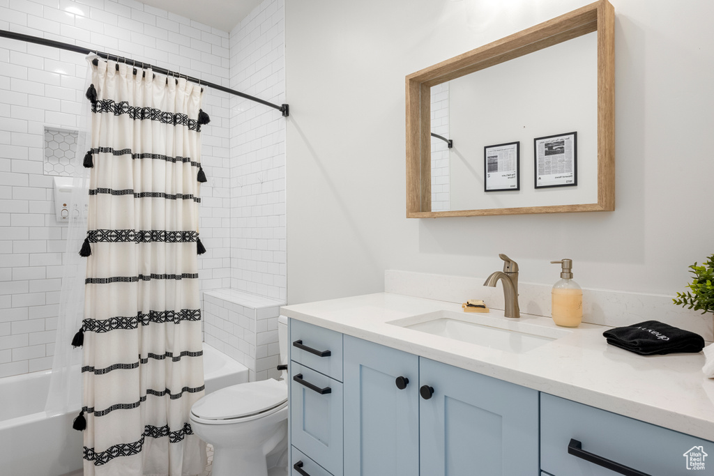 Bathroom with shower / bath combo with shower curtain, toilet, and vanity