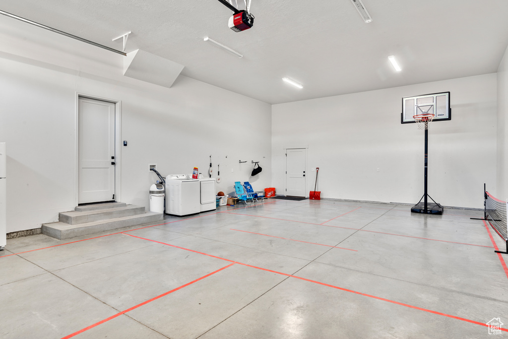 Garage featuring a garage door opener and washer and dryer
