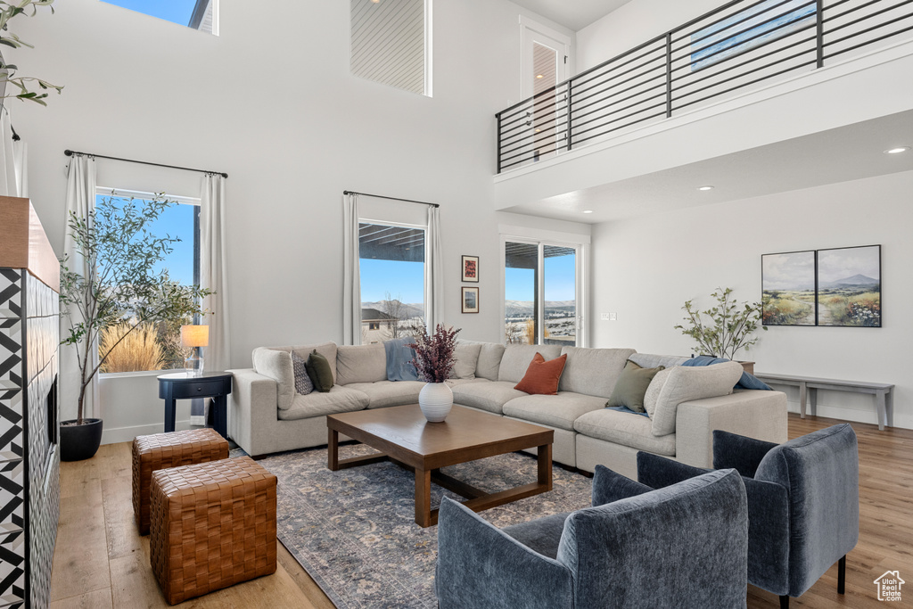 Living room featuring a high ceiling, wood finished floors, and a wealth of natural light