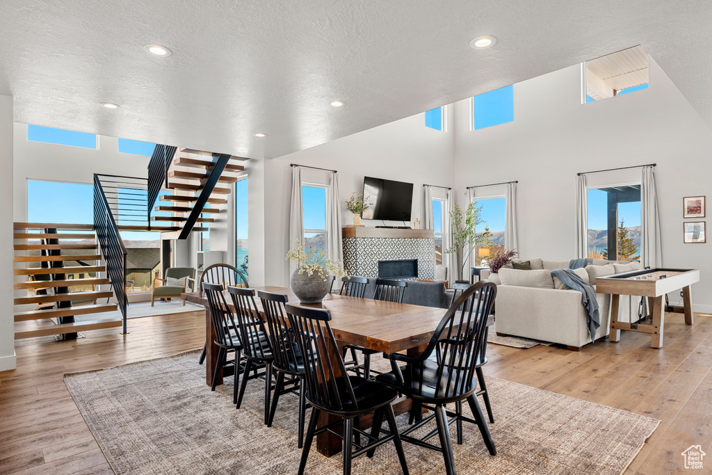 Dining area with stairs, baseboards, light wood-style flooring, and a fireplace
