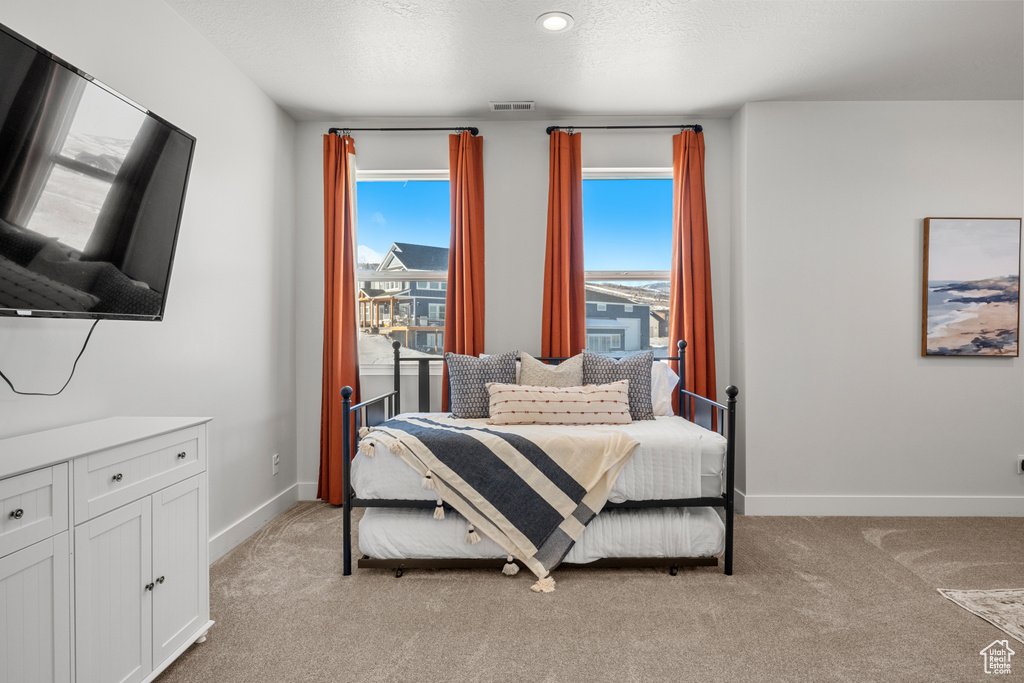 Bedroom featuring baseboards, visible vents, and light carpet