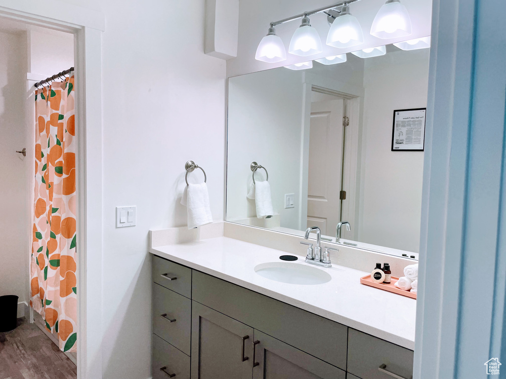 Full bathroom featuring vanity, wood finished floors, and a shower with shower curtain