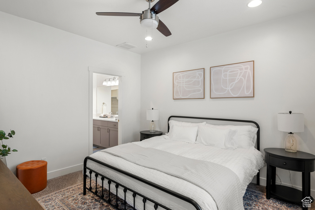 Bedroom with visible vents, carpet floors, baseboards, ceiling fan, and connected bathroom