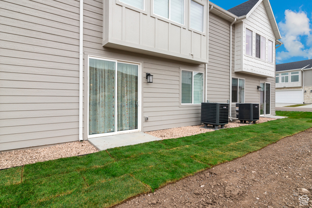Back of property featuring board and batten siding and cooling unit