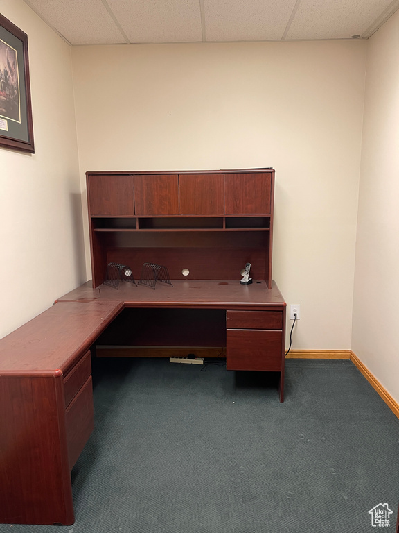 Unfurnished office featuring built in study area, carpet floors, and a drop ceiling