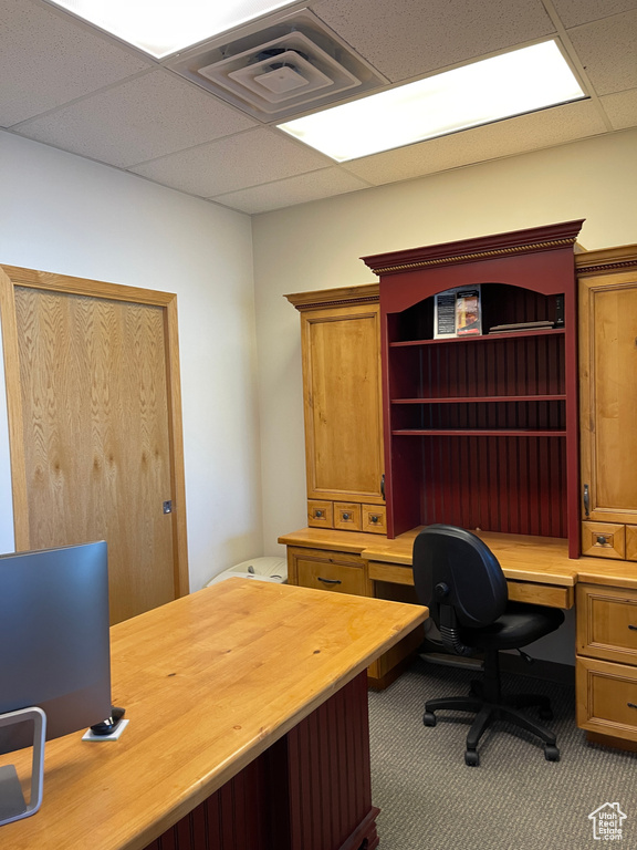 Home office with carpet floors, a drop ceiling, built in desk, and visible vents