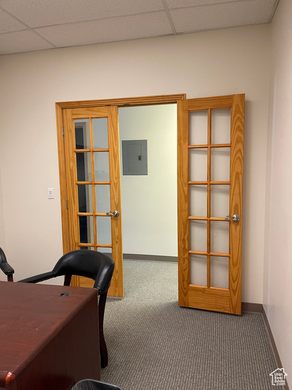 Office with carpet flooring, baseboards, a drop ceiling, and electric panel