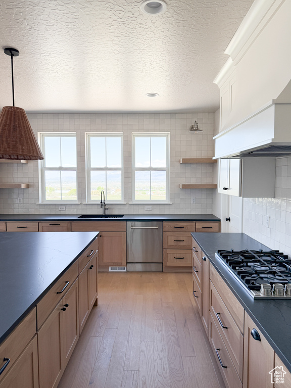 Kitchen with appliances with stainless steel finishes, dark countertops, and tasteful backsplash