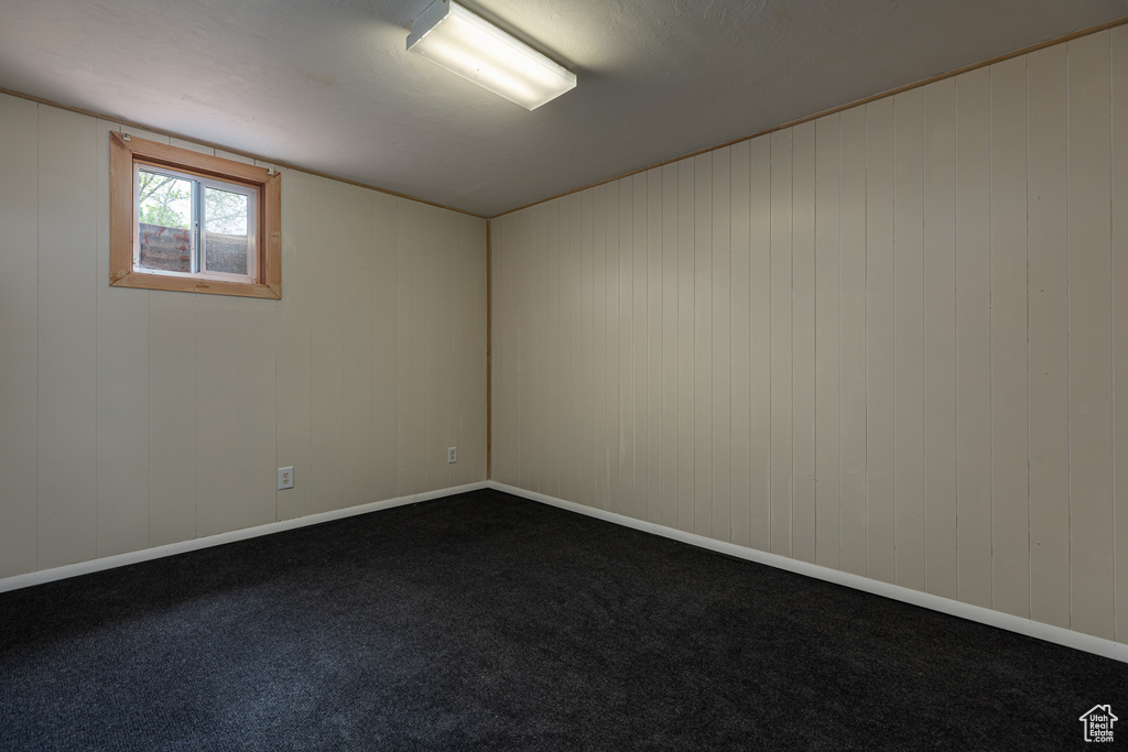Unfurnished room featuring dark carpet