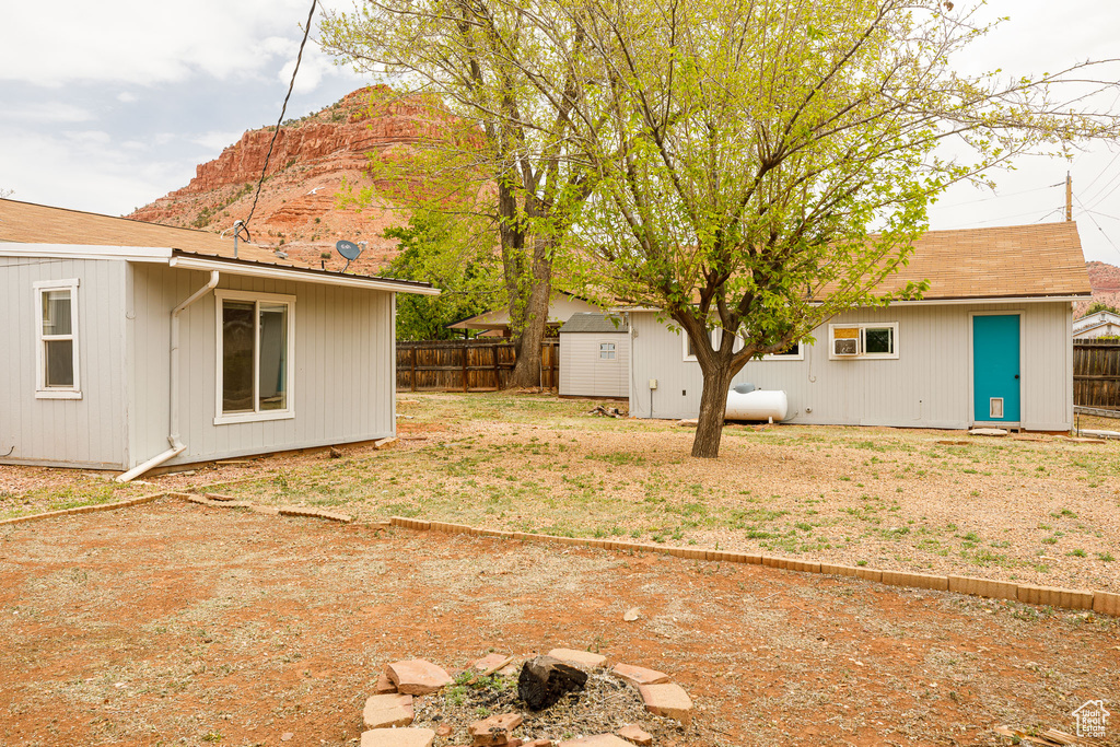 View of yard featuring a fenced backyard, an outdoor structure, and a mountain view