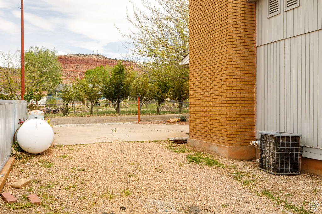 View of yard featuring central AC unit and fence