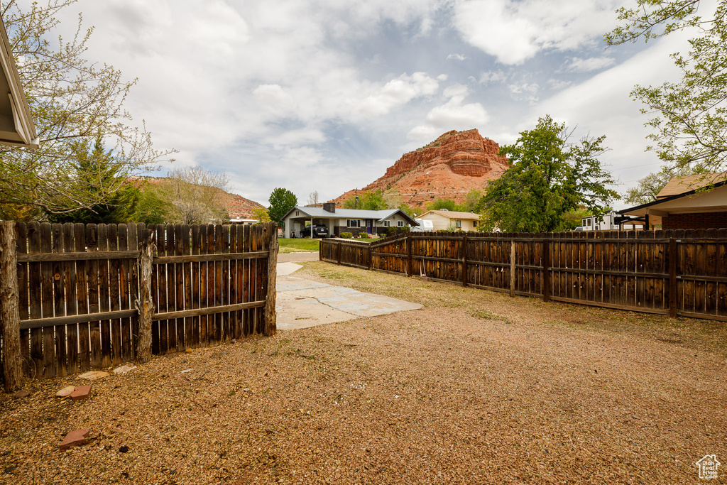 View of yard featuring a fenced backyard, a mountain view, and a patio area