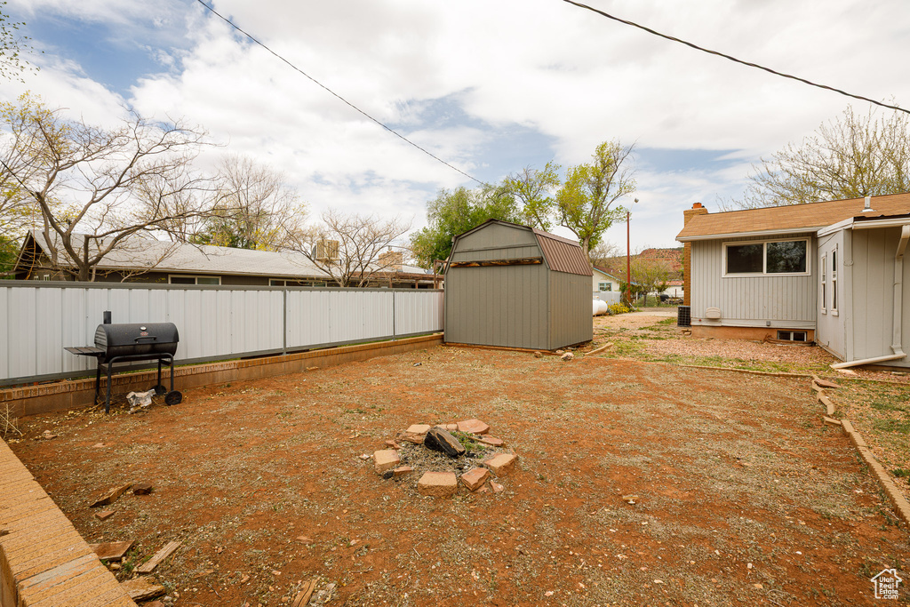 View of yard featuring fence, an outbuilding, and a storage unit