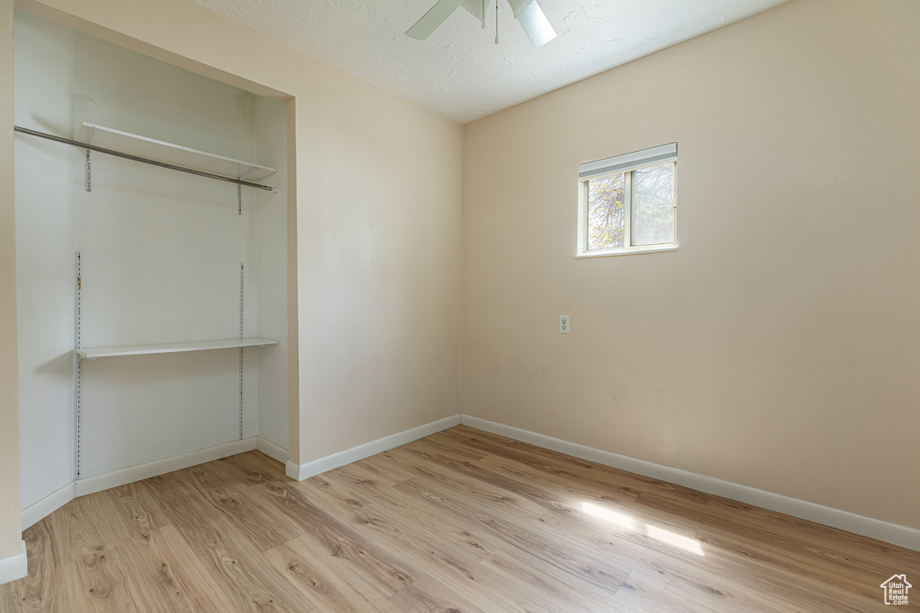 Unfurnished bedroom featuring baseboards, ceiling fan, light wood finished floors, and a closet