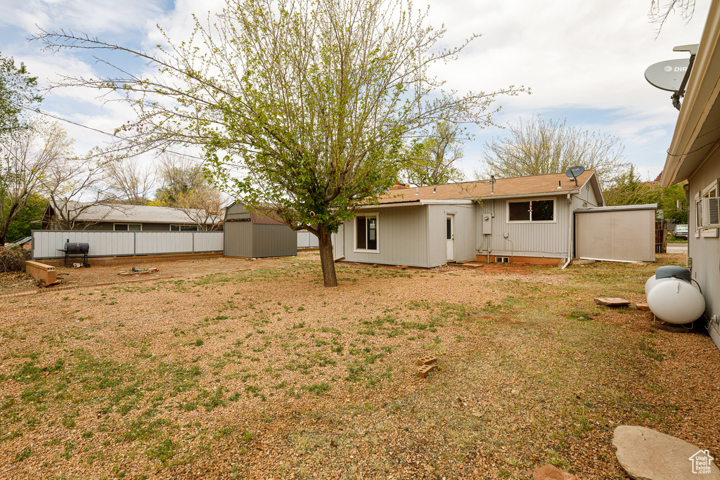 View of yard featuring a storage unit, an outdoor structure, and fence