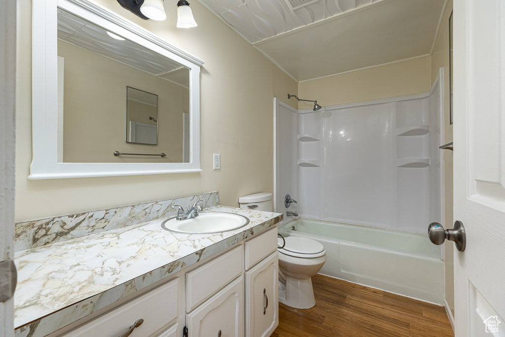 Bathroom featuring vanity, shower / bathing tub combination, toilet, and wood finished floors