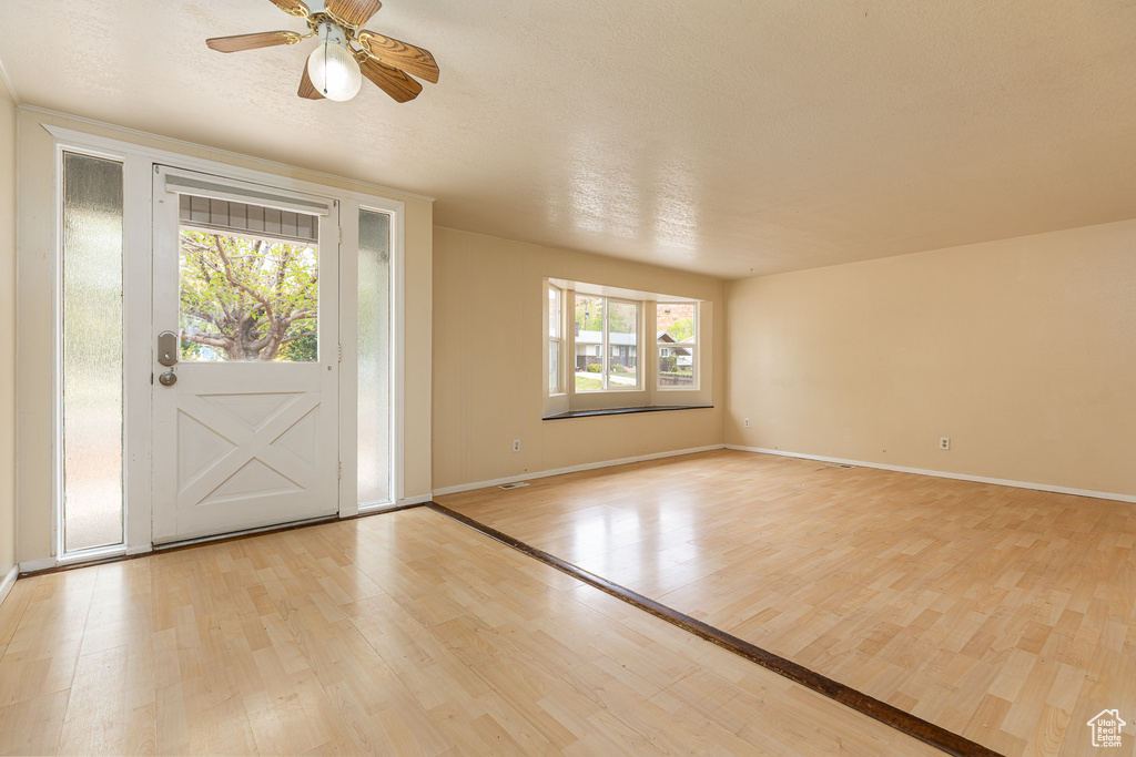 Entrance foyer featuring light wood-style floors, baseboards, and ceiling fan