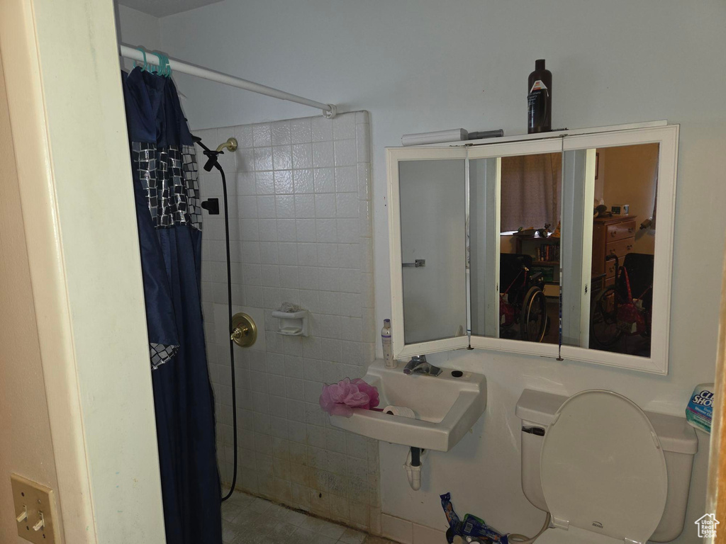 Bathroom with a sink, toilet, and tiled shower