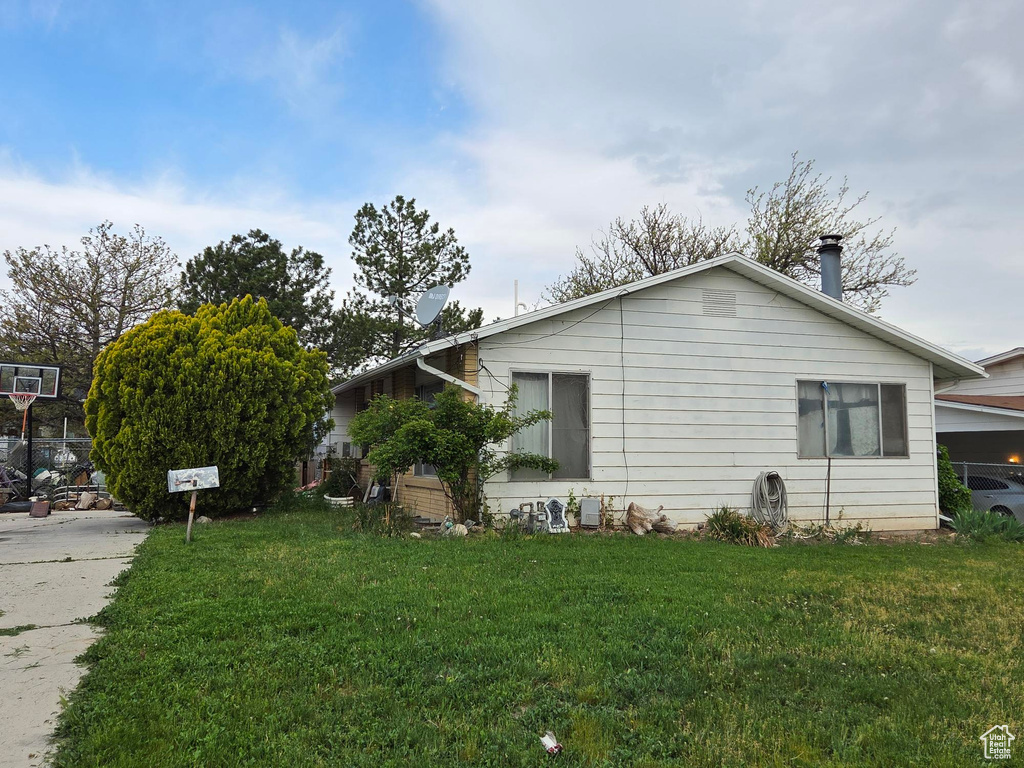 View of property exterior featuring a lawn